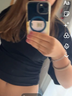 Svart tshirt - En svart croppad topp med korta ärmar och rund halsringning från gina tricot. Sitter tajtare runt midjan! . Sitter tight och har en enkel, stilren design som passar till jeans eller kjol. Perfekt för dig som gillar en basic men snygg look.