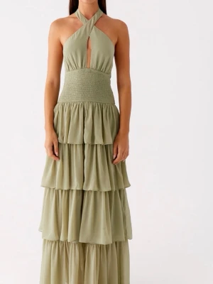 Ljusgrön balklänning - Säljer en ljusgrön långklänning med flera lager volanger och smock i midjan. Klänningen har halterneck och en liten öppning framtill. Perfekt till en bal! Inte använda någon gång då den är lite för stor för mig💞