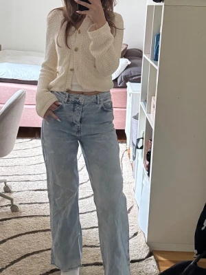 Ljusblåa raka jeans med hög midja - Säljer ett par ljusblå jeans med rak passform och hög midja. Jeansen har klassisk femficksdesign och stängs med knapp och dragkedja. Perfekta för en avslappnad och trendig look. Materialet är denim i bomull.