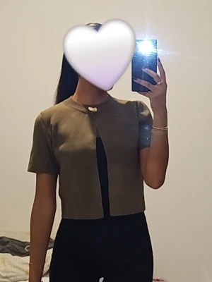 Kort olivgrön kofta med knapp från zara  - Snygg kort kofta i olivgrönt med en dekorativ knapp framtill. 