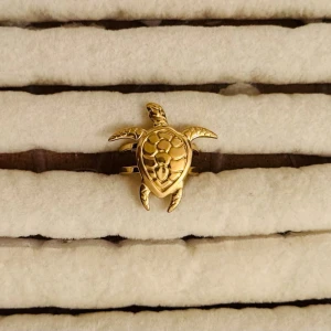 Guldfärgad ring med sköldpaddsmotiv - Unik ring i guldfärgad formad som en sköldpadda. Detaljerad design med skalstruktur och utstickande ben och huvud. Perfekt accessoar för dig som gillar djurmotiv och vill sticka ut med något annorlunda.
