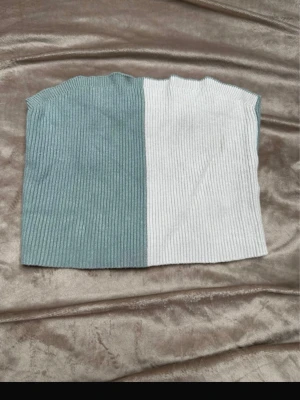 Ribbad tvåfärgad bandeau topp - Trendig bandeau topp i ribbat material med tvåfärgad design i ljusblått och vitt. Toppen är axelbandslös och croppad, perfekt för att styla med höga jeans eller kjol. Mjuk och stretchig för en bekväm passform. Rök och djurfritt hem. Pruta gärna !🌸