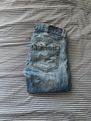 Ljusblå dondup George  - Säljer ett par ljusblå jeans från dondupe med slitna detaljer vid fickorna. Jeansen är gjorda av denim. Väldigt bra skicka då jag nästan aldrig har använt dom. Skicka gärna om du undrar något, priset är såklart inte hugget i sten 🪨😊