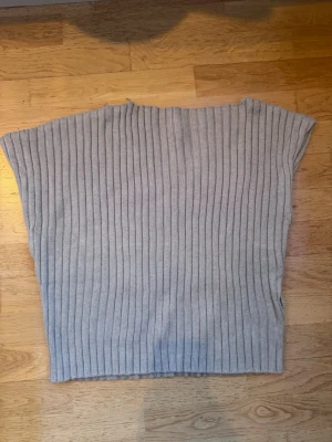 Grå ribbstickad topp - Supercool asymmetrisk stickad topp från Zara! Den är helt oanvänd (dock utan prislapp) och säljer den då toppen var för liten för mig. 