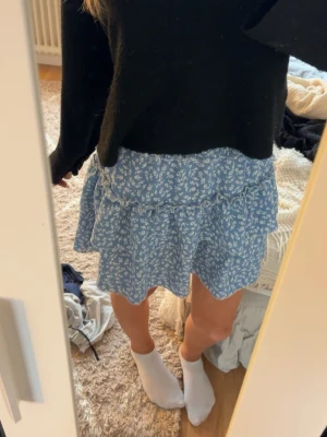 Blå blommig volangkjol - Söt blommig kjol från SHEIN. Använd fåtal gånger, inga tecken på användning. Skriv om ni har frågor eller för fler bilder💕
