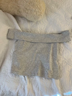 Ljusgrå axelbandslös tubtopp - Snygg ljusgrå tubtopp i mjukt bomullsmaterial. Toppen är axelbandslös och har en enkel, clean design som passar perfekt till jeans eller kjol. Perfekt för varma dagar eller som layering-piece.