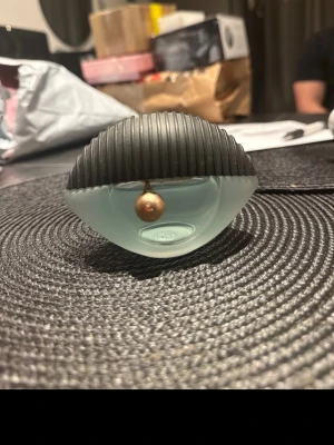 Kenzo World Eau de Parfum - Kenzo World Eau de Parfum har en unik, ögonformad flaska i frostat ljusblått glas med svart ribbad plastkork och en liten guldfärgad berlock. Flaskan är modern och sticker ut med sin kreativa design, perfekt för dig som gillar snygga detaljer på parfymhyllan.