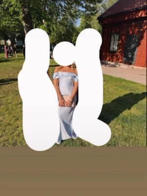 Ljusblå axelbandslös långklänning - Säljer en elegant ljusblå långklänning med off shoulder-design och figurnära passform. Klänningen har en slät yta och faller snyggt längs kroppen. Perfekt för bal eller student. Köpt på ASOS, nypris 1700 slutsåld på hemsidan 