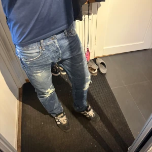 Ralph Lauren Denim & Supply - Säljer ett par blå jeans med slitningar. Jeansen är i passform slim. 