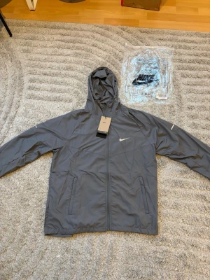 Nike miler jacka  - Helt ny och oanvänd Nike miler jacka med tags kvar i färgen grå