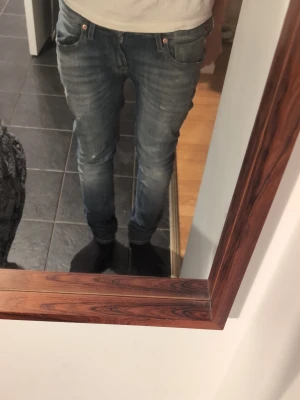 Blå slim fit jeans herr - Snygga blå slim fit jeans med klassisk femficksdesign och lätt slitna detaljer. Jeansen har normal midja och smal passform hela vägen ner. Perfekta för dig som gillar en modern och avslappnad stil.