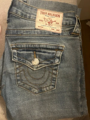 True Religion Joey Low Rise Flare Jeans - Säljer ett par ljusblå True Religion jeans, modell Joey Low Rise Flare. Aldrig använda, köpa för 1500, säljer billigt för vill ha sålt 