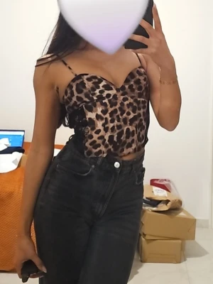 Leopardmönstrad korsettopp - Snygg leopardmönstrad korsettopp med tunna axelband och hjärtformad urringning. Toppen har en croppad passform och är perfekt för dig som vill sticka ut. Materialet känns mjukt och följsamt mot kroppen.