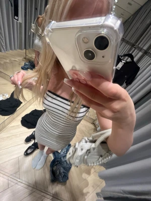Randig axelbandslös kort klänning från h&m i storlek xxs - Säljer en tight, axelbandslös kort klänning i vitt med svarta horisontella ränder. Klänningen har en kroppsnära passform och är perfekt för dig som gillar en enkel men snygg stil. Materialet känns mjukt och stretchigt.