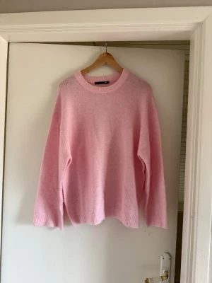 Ljusrosa oversized stickad tröja - Mysig ljusrosa stickad tröja med rund halsringning och avslappnad passform. Tröjan har långa ärmar och ribbade muddar vid ärmslut och nederkant. Perfekt för lager på lager och en soft look. Kan diskutera pris 