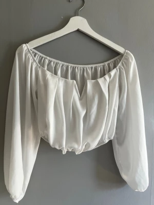 Vit offshoulder blus med puffärm missay  - Trendig vit offshoulder blus med långa puffärmar och resår i midjan och vid axlarna. Toppen har en lätt v-ringad detalj framtill och är gjord i ett mjukt, tunt tyg som ger ett luftigt intryck. Perfekt för dig som gillar romantisk och stilren look. Toppen är från missay, storleken skulle jag säga är en S/M priset går att diskuteras🩷 tröjan har en liten fläck se bild 2 🩷 har använt toppen max 2 gånger så väldigt bra sick.