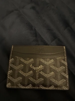 Zara kort  - Snyggt och stilrent kortfodral  brunt med det klassiska-mönstret i beige och vitt. Fodralet har flera kortfack och är tillverkat i läder och canvas. Perfekt för dig som vill ha en exklusiv och smidig plånbok i fickan.