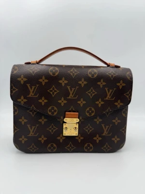 Louis Vuitton Monogram handväska - Tidlös investering. Lyxig begagnad LOUIS VUITTON METIS BANDOULIERE Monogram-väska. Mångsidig och hållbar väska som erbjuder ikonisk stil och förstklassig kvalitet.
