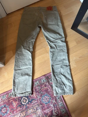 Beiga Levi's 513 jeans W30 L32 - Snygga knappt använda  beiga jeans från Levi's modell 513 med raka ben och klassisk femficksdesign. Tillverkade i ett mjukt bomullsmaterial som är skönt att bära. Passar perfekt till en avslappnad och stilren look.