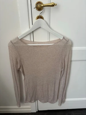 Intimissimi - Superskön beige långärmad topp från Intimissimi i en mjuk mix av ull och kashmir. Enkel och stilren design med rund halsringning och smal passform. Perfekt att bära som lager eller för en clean look.