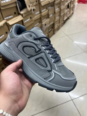 Grå chunky sneakers med meshdetaljer - Snygga grå sneakers med chunky sula och coola meshdetaljer. Skon har mörkgrå snören och en sportig vibe med flera lager av material och mönster. Perfekt för dig som gillar streetstyle och vill ha något bekvämt och trendigt på fötterna.