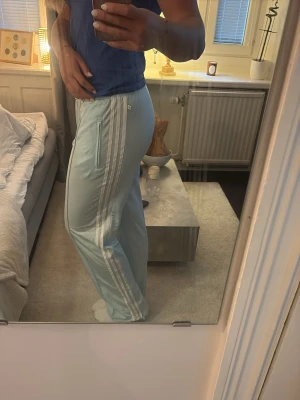 Adidas byxor - Ljusblå snygga och sköna Adidasbyxor, storlek M/L, jag är 174cm lång, rensar så vill bli av med snabbt och uppskattar om du kan hämta upp i stan