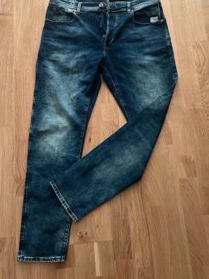 Mörkblå jeans från G-Star RAW - Snygga mörkblå jeans från G-Star RAW med klassisk femficksmodell och slitna detaljer. Jeansen har raka ben och tydliga kontrastsömmar. Perfekta för en avslappnad streetstil och tillverkade i slitstarkt denimtyg.