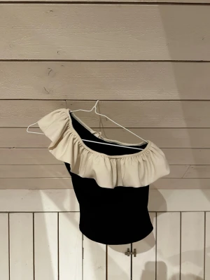 Svart one shoulder topp med volang - Söt topp med volang, knappast använts men de sista bilden för en svag dust kant på insidan. Går förmodligen bort i en tvätt, inget som syns utifrån!