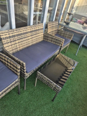 Utemöbelset tectake rotting & glas - Säljer ett utemöbelset från tectake i flätad konstrotting med beige och grå toner. Setet innehåller en soffa, två fåtöljer med mörkgrå dynor och ett rektangulärt bord med svart glasskiva. Perfekt för altan eller uteplats.