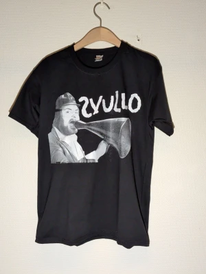 Svullo svart fruit of the loom t-shirt storlek Medium - T-shirt med screentryck Svullo Storlek:Medium  Merchandise| Vintage motiv | Rock | Pop | rare | band