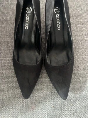 Svarta pumps från Boohoo, storlek 39 - Snygga svarta pumps från Boohoo i storlek 39. Skorna har spetsig tå och klassisk design med slät yta. Perfekta för dig som gillar stilrena och trendiga skor. Materialet är syntet och färgen är helsvart. Kan tänka mig att sänka priset vill bara bli av med dom och tjäna pengar, är fattig student😃😃
