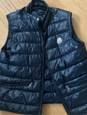 Moncler Gui väst mörkblå - Mörkblå Gui väst från moncler i storleken 2 (S). Knappt använd, bra skick och köpt från merchsweden. 
