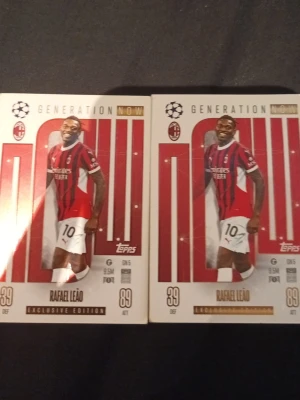 Fotbollskort Rafael Leão Topps - Två exklusiva fotbollskort från Topps med Rafael Leão i AC Milans rödsvarta matchställ. Korten har texten 'Generation Now' och är märkta med 'Exclusive Edition'. Snygg design med guld- och röda detaljer, perfekt för samlare.