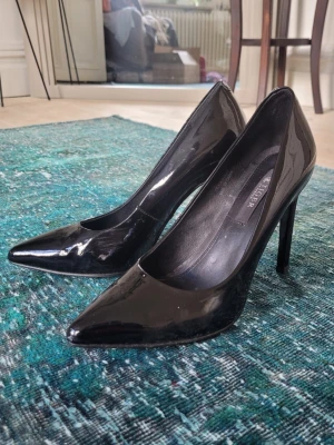 Svarta klackar - Snygga svarta pumps i lack från Tiger of Sweden med spetsig tå och hög klack. Klassisk och stilren modell som ger en elegant look. Perfekta för dig som vill ha en tidlös sko med lite edge. Endast använd en gång 🩷 nypris ca 2500!