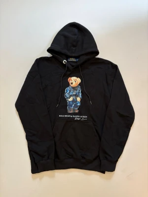 Ralph Lauren polo bear hoodie - Svart Ralph Lauren polo bear hoodie // 10/10 skick aldrig använd // storlek M // längd 64cm axelbredd 49cm armlängd 59cm // skriv vid minsta fråga eller fundering🤝