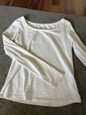Vit långärmad topp från lager 157 - En basic vit långärmad topp från 157 i mjuk bomullsblandning med rund halsringning. Perfekt att styla med jeans eller kjol för en clean look. Materialet är 95% bomull och 5% elastan vilket gör den stretchig och bekväm.