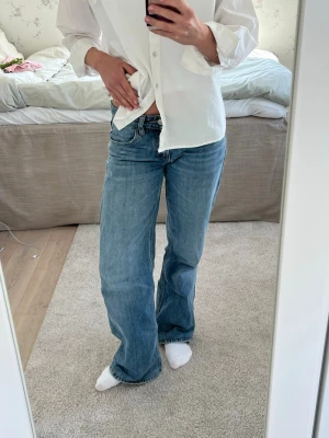 Blå zara raka jeans med hög midja - Säljer ett par klassiska blå jeans från zara.  med rak passform och hög midja. Jeansen har fem fickor och stängs med dragkedja och knapp. Perfekta till en avslappnad look och passar till det mesta. Materialet är denim i bomull.