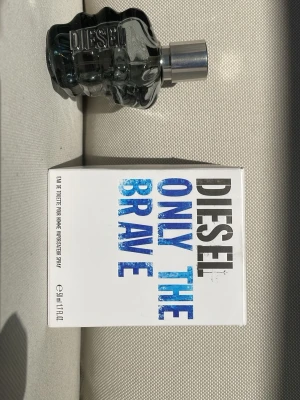 Diesel Only The Brave parfym 50ml - Diesel Only The Brave är en herrparfym med en unik flaska formad som en knytnäve i mörkgrått glas och silverfärgad kork. Doften är fräsch och maskulin och passar perfekt för sommaren och våren.