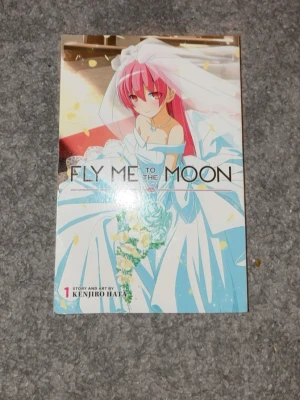 Fly Me to the Moon Volym 1 Manga - Manga-bok 'Fly Me to the Moon' volym 1 av Kenjiro Hata. Boken är i pocketformat och tryckt på papper. Perfekt för dig som gillar romantik och anime.