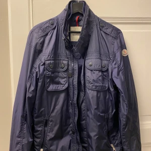 Mörkblå jacka från Moncler - Tjena säljer nu min jacka som jag ärvt av min pappa. Det är en moncler och den passar till dig från 183 till 187 cm nästan aldrig använd har bara hängt nere i källarn vid hans andra jackor perfelt för lite varmare vinter dagar eller vår. Mvh Vince