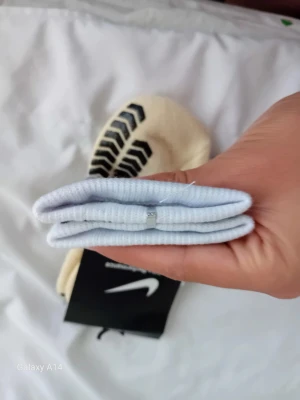 Nike Pro vita sportstrumpor - Nike Pro sportstrumpor i vitt med svarta detaljer och logga. Strumporna är ribbade och har en sportig design med extra grepp under foten. Perfekta för dig som gillar träning och vill ha snygga och funktionella strumpor.