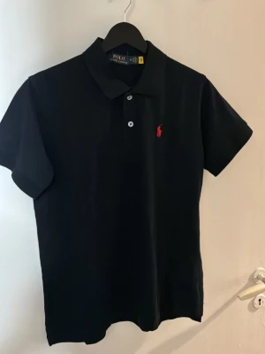 Svart pikétopp från Polo Ralph Lauren - Svart pikétopp från Polo Ralph Lauren. Den säljs pga att den var för liten för mig. Storleken är medium men skulle säga att den är S om jag fick bestämma. Tröjan är helt ny med lappen kvar.   Hör av er. Prisförslag tas emot men inga skambud 