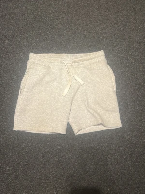 Russemerch shorts - Säljer ett par beige mjukisshorts från R i storlek M. Shortsen har snörning i midjan, två sidofickor och är gjorda i ett mjukt material som passar perfekt för chill dagar. Enkel och clean design som är lätt att matcha.