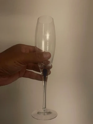 Elegant champagneglas i glas - Säljer ett elegant champagneglas med smal kupa och lång, tunn fot. Glaset är helt genomskinligt och har en klassisk form som passar perfekt till bubbel och festliga tillfällen.