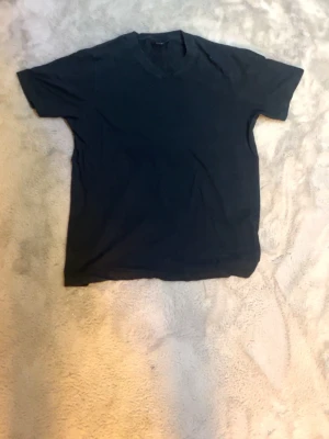 Svart v-ringad t-shirt - En basic svart t-shirt med v-ringning och korta ärmar. Perfekt till jeans eller shorts för en enkel och clean look. T-shirten är i mjukt material och har en klassisk passform.