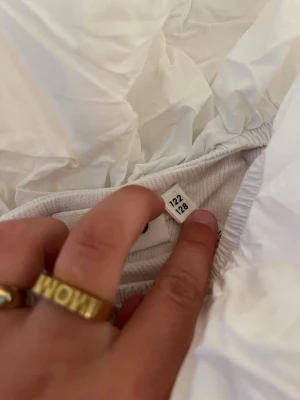Vit dunjacka från Molo - Säljer en vit dunjacka från Molo i storlek 122/128. Jackan har en klassisk puffig design och elastiska muddar vid ärmsluten. Perfekt för kalla vinterdagar och riktigt snygg till alla outfits.
