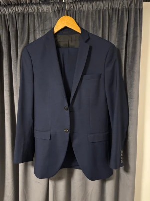 Jack and Jones mörkblå kostym - Snygg och stilig mörk/marinblå kostym från Jack and Jones. Köptes för 3 år sen för cirka 2500kr. Användes 1-2 gånger. Pris diskuteras ej. 