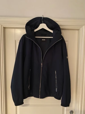 Windbreaker Boss - Tjena! Säljer nu dessa sjukt snygga windbreaker från Boss. Nypris cirka 4000. Storlek 52(L) och i nyskick. Priset är ej hugget i sten så hör av dig vid minsta fundering:)