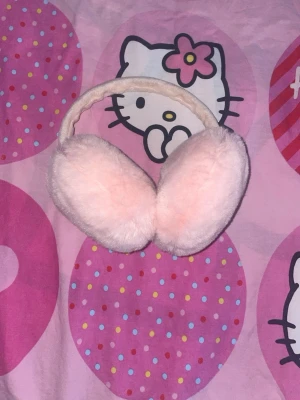 Fluffiga rosa öronmuffar - Supersöta öronmuffar i ljusrosa fluffigt material. De har en mjuk båge och stora, runda örondelar som täcker öronen ordentligt. Perfekta för att hålla värmen och addera en gullig touch till din outfit.