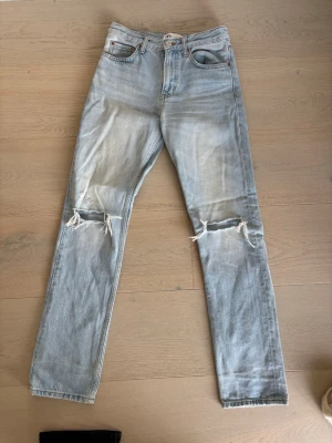 Ljusblå raka jeans med hål - Säljer ett par ljusblå Zara jeans med raka ben och slitna detaljer över knäna för en cool & avslappnad look. Klassisk femficksmodell. Perfekta för våren och sommarens dagar! 